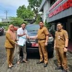 Roike Kodoati saat mengembalikan Mobnas di Kantor Dinas Pangan Sulut, (foto : istimewa)