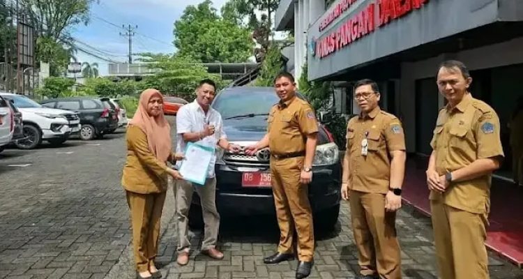 Roike Kodoati saat mengembalikan Mobnas di Kantor Dinas Pangan Sulut, (foto : istimewa)