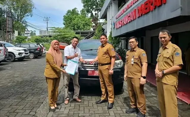 Roike Kodoati saat mengembalikan Mobnas di Kantor Dinas Pangan Sulut, (foto : istimewa)