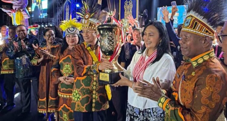 Ketua Umum LPPD Provinsi Sulawesi Utara, Anik Yulius Selvanus saat menerima trophy jauara umum piala presiden. (dok.istimewa)