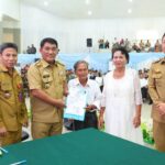 Gubernur YSK menyerahkan dokumen kependudukan secara simbolis pada acara Pencatatan Perkawinan Massal Pemprov Sulut di Aula Mapalus, Manado, Selasa (21/7/2026)