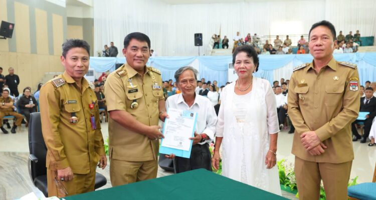 Gubernur YSK menyerahkan dokumen kependudukan secara simbolis pada acara Pencatatan Perkawinan Massal Pemprov Sulut di Aula Mapalus, Manado, Selasa (21/7/2026)